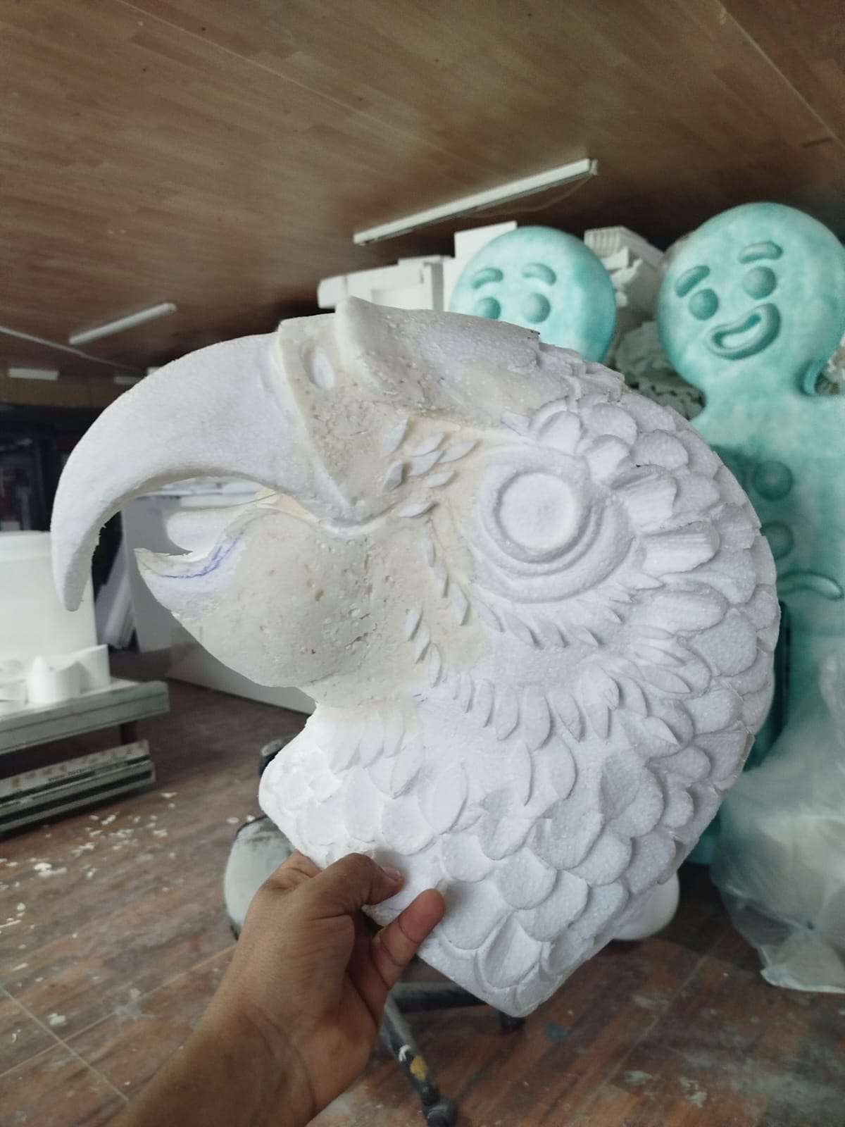 Escultura de cabeza de loro tallada en espuma blanca