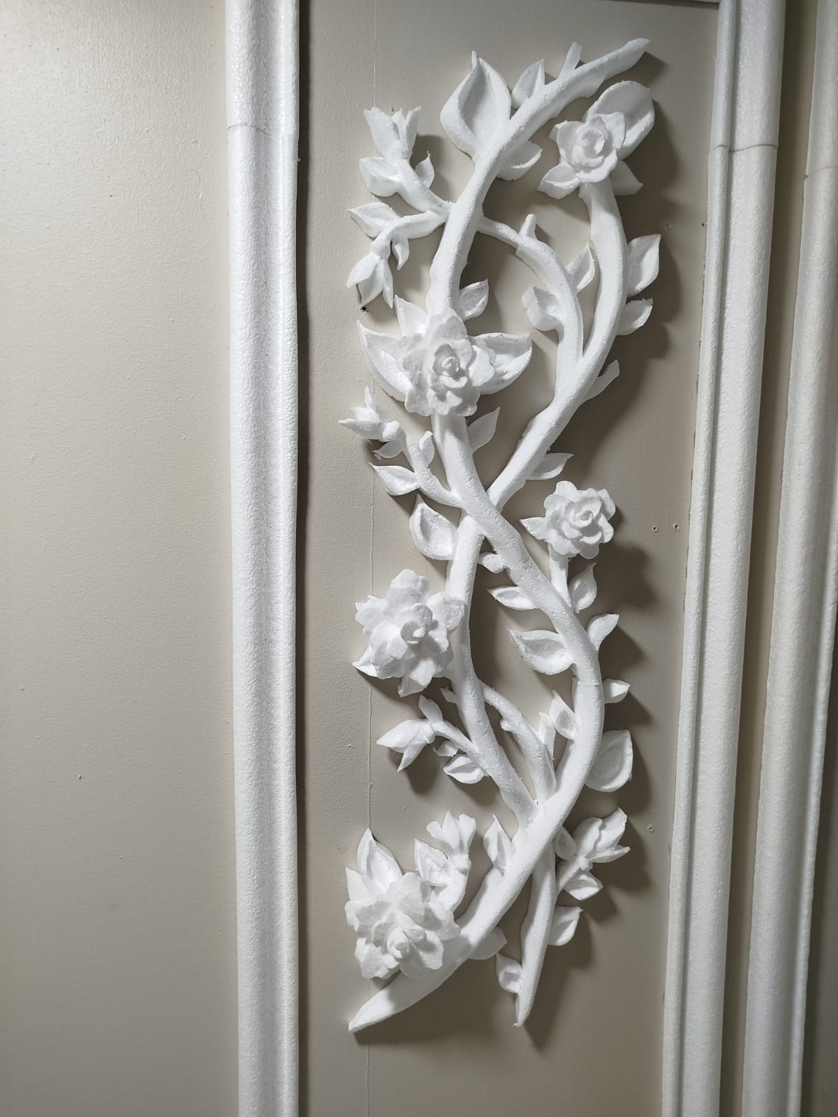 Decoración de pared en relieve con flores y enredaderas blancas